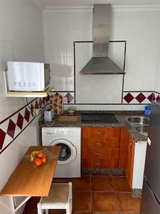 uma cozinha com uma máquina de lavar roupa e um micro-ondas em Apartamento El convento em Almodóvar del Río