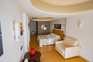 a hotel room with a bed and a chair at Taormina Panoramic Hotel in Taormina