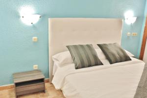 a bedroom with a white bed and a blue wall at Estudio Paraiso del Sur in Playa Paraiso