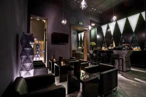 un bar con sillas negras y barra de bar en Platinum Palace Boutique Hotel & SPA en Wroclaw