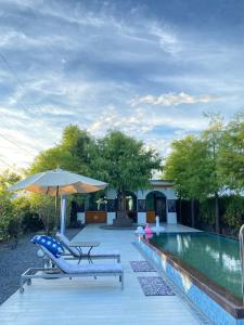 a swimming pool with two lounge chairs and an umbrella at 蘭庭 Villa民宿 B&B in Yuanshan