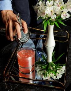 a person is grilling a drink in a vase at Platinum Palace Boutique Hotel & SPA in Wrocław