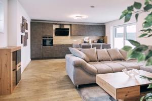 uma sala de estar com um sofá e uma cozinha em Harener Hafentraum- 90qm Wohnung mit 40qmTerrasse-kostenloses parken- nähe Schloss Dankern em Haren