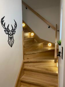 a set of stairs with a deer head on the wall at Domek RogatY in Szczawnica