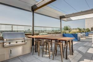 an outdoor patio with a wooden table and a grill at Culver City 2br w gym lounge roof nr 405 LAX-1001 in Los Angeles