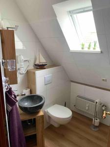 a bathroom with a sink and a toilet at Über den Dächern der Stadt in Bremervörde