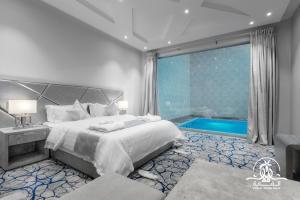 a bedroom with a large bed and a swimming pool at Shalalat Al Ghaba Chalets in Taif +73 photos