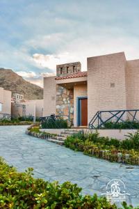 a house with a stone walkway in front of it at Shalalat Al Ghaba Chalets in Taif
