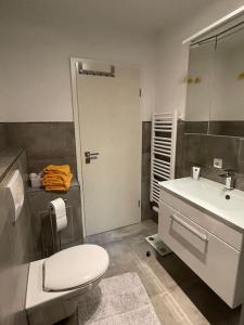 a bathroom with a white toilet and a sink at Ferienwohnung mit Vollaustattung in Waldbronn