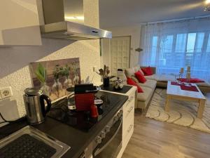 a kitchen with a stove top oven next to a living room at Ferienwohnung mit Vollaustattung in Waldbronn