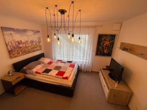 1 dormitorio con 1 cama y TV en Ferienwohnung mit Vollaustattung, en Waldbronn