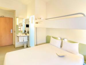 a bedroom with a bunk bed and a bathroom at Ibis Budget Madrid Calle Alcalá in Madrid