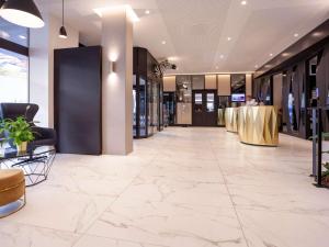 eine leere Lobby mit Marmorboden in einem Gebäude in der Unterkunft Mercure Biel in Biel