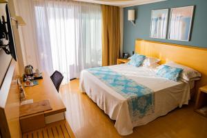 a hotel room with a bed and a desk at Taormina Panoramic Hotel in Taormina