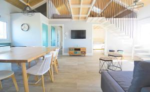 a dining room and living room with a table and chairs at GALIHOST - Apartamentos Mamuela in Ribadumia