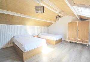 a bedroom with two beds and a vaulted ceilings at GALIHOST - Apartamentos Mamuela in Ribadumia