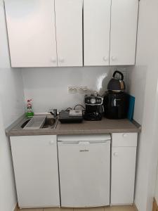 a kitchen with white cabinets and a tea pot on a counter at Piata Muzeului 1 in Cluj-Napoca