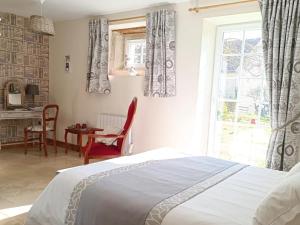 a bedroom with a bed and a table and a window at La Grange de Moisey in Marigny-lès-Reullée