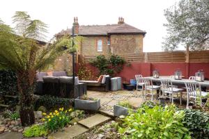 a patio with a table and chairs in a garden at Veeve - Sunshine Botanical in London