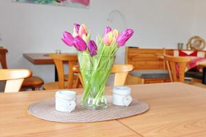 un vaso di tulipani viola seduto su un tavolo di Pension An der Kamske, 3BZ 2 a Lübbenau