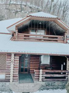 a log cabin with snow on top of it at Апартаменти з 2 спальними кімнатами in Mukacheve