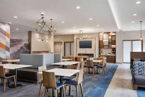 a restaurant with tables and chairs and a kitchen at La Quinta Inn & Suites by Wyndham Del Rio in Del Rio