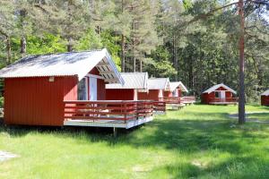 a row of red cabins in a field of grass at Raet Camping in Færvik