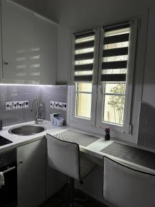 uma cozinha branca com um lavatório e uma janela em Dominik apartment em Patmos