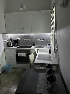 a kitchen with white cabinets and a stove top oven at Dominik apartment in Patmos