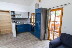 een keuken met blauwe kasten en een bank in een kamer bij Ferienwohnung Hilde in Miesbach