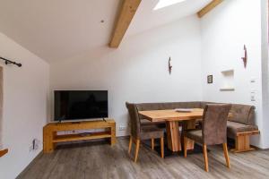 ein Wohnzimmer mit einem Tisch, einem Sofa und einem TV in der Unterkunft Ferienwohnung Hilde in Miesbach
