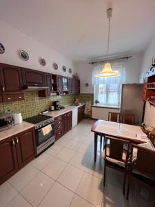 a kitchen with wooden cabinets and a table in it at Apartament ALMAR Cieplice-Zdrój in Jelenia Góra +22 photos