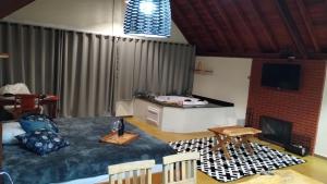 Sala de estar con cama y mesa en Chales Sabor Dos Ventos, en Gonçalves