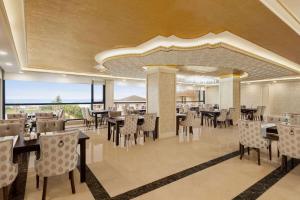 a rendering of a restaurant with tables and chairs at Ramada Plaza by Wyndham Silivri in Silivri