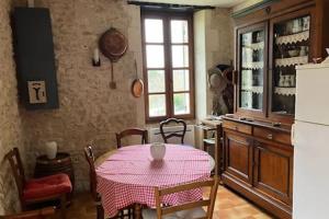 een keuken met een tafel met een roze tafelkleed erop bij Cottage Ker Bunny à Feraillou 