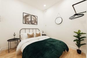 una camera da letto con un letto con una coperta verde sopra di Stylish 2 Bedroom Flat in Ilford, London a Ilford