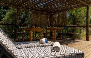 terraza de madera con mesa y sillas en el porche en Baluleni Safari Lodge, en Grietjie Game Reserve