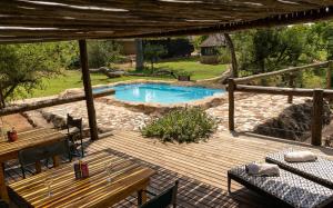 a wooden deck with a pool in a yard at Baluleni Safari Lodge in Grietjie Nature Reserve