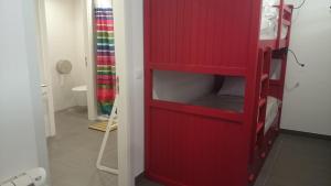 een rode boekenplank in een kamer met een badkamer bij Lab Hostel Nazare in Nazaré +13 foto's