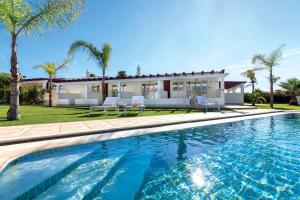 une villa avec une piscine en face d'une maison dans l'établissement Hotel Rural Brícia Du Mar, à Ferragudo
