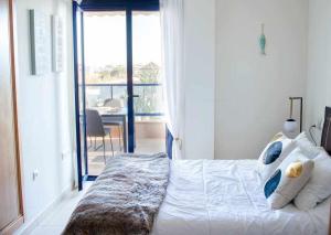 a bedroom with a bed with a view of a balcony at Coqueto apartamento con vistas al mar in Denia