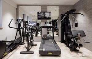a gym with several treadmills and tread machines at The Corner Duomo Hotel in Milan