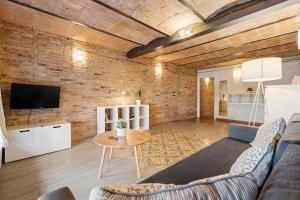 a living room with a brick wall at Flateli Fabra in Barcelona