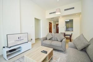ein Wohnzimmer mit einem Sofa und einem TV in der Unterkunft Cozy 1 Bedroom with Study room in Dubai Marina - Ideal for 3 Guests - PRK in Dubai