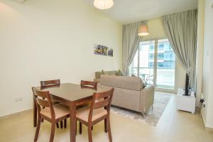 ein Wohnzimmer mit einem Tisch, Stühlen und einem Sofa in der Unterkunft Cozy 1 Bedroom with Study room in Dubai Marina - Ideal for 3 Guests - PRK in Dubai