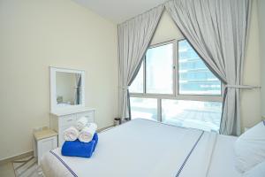 ein Schlafzimmer mit einem Bett mit zwei Handtüchern darauf in der Unterkunft Cozy 1 Bedroom with Study room in Dubai Marina - Ideal for 3 Guests - PRK in Dubai