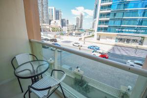 einen Balkon mit 2 Stühlen und Straßenblick in der Unterkunft Cozy 1 Bedroom with Study room in Dubai Marina - Ideal for 3 Guests - PRK in Dubai