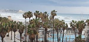 een uitzicht op een resort met palmbomen en de oceaan bij Armon Hayarkon Hotel in Tel Aviv