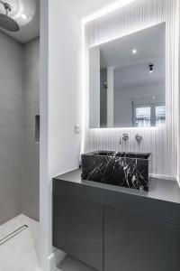 uma casa de banho com um lavatório preto e um espelho em Alba em Atenas