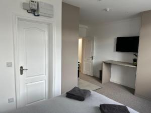 biały pokój z łóżkiem i telewizorem w obiekcie Spectacular Modern, Brand-New, 1 Bed Flat, 15 Mins Away From Central London w mieście Hendon